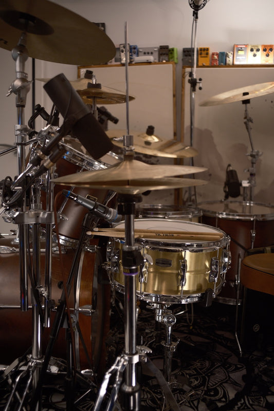 Drum set with various drums and cymbals in a room setting.